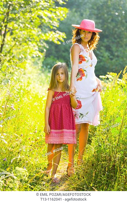 Mother and daughter are walking in the woods