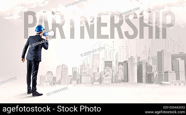 Young businessman with hard hat and PARTNERSHIP inscription, new business opportunity concept