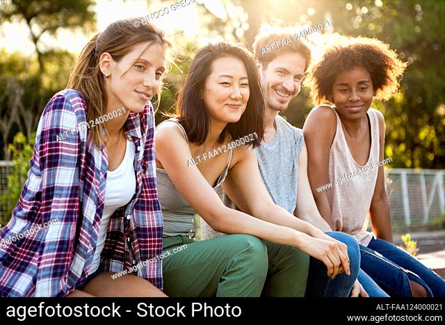 Group of young friends sitting together in park