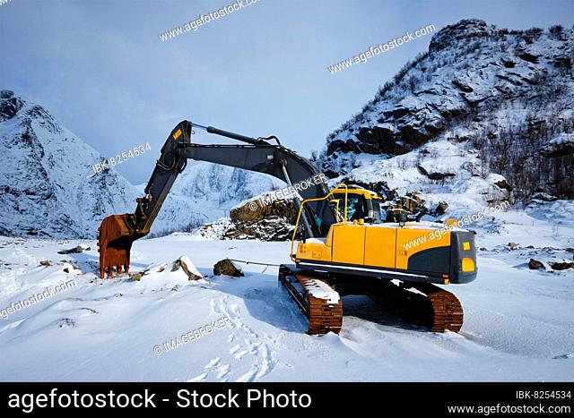 Old excavator with excavator bucket in winter, Road construction in snow, Lofoten islands, Norway, Europe
