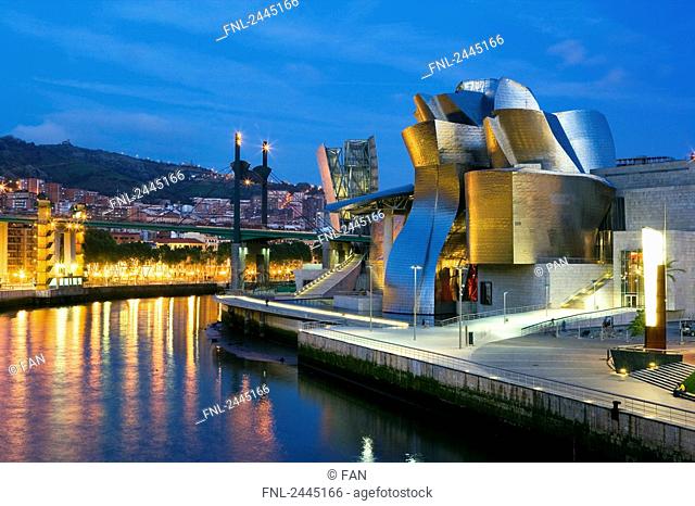 Art museum lit up at dusk, Guggenheim Museum, Bilbao, Spain
