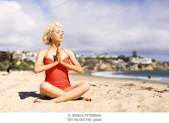 Portrait of blond woman on beach practicing yoga