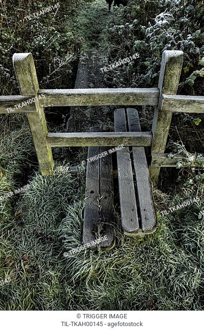 A stile on a footpath with winter frost
