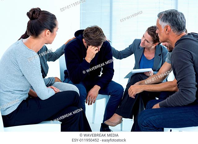 Concerned patients comforting another in rehab group