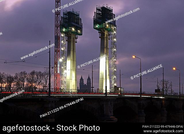 22 December 2021, Saxony-Anhalt, Magdeburg: View of the construction site with the two pylons at dusk. The new construction of the Strombrücke was started in...