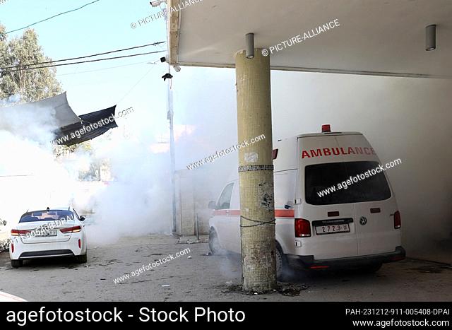12 December 2023, Palestinian Territories, Jenin: Tear gas billows next to a hospital amid clashes between Palestinian protesters and Israeli military vehicles...