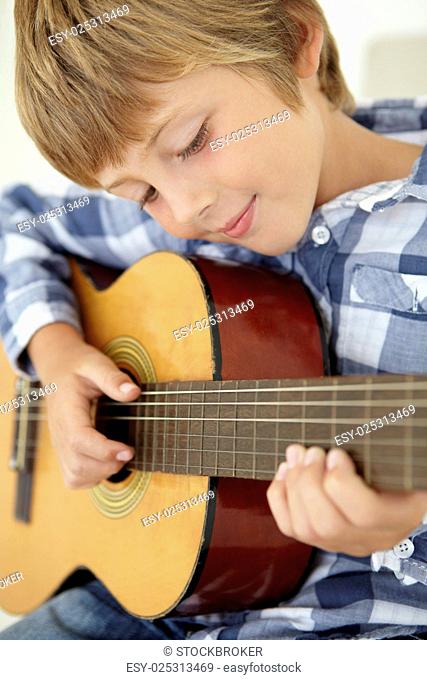 Young boy playing acoustic guitar