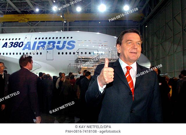 (dpa) - German Chancellor Gerhard Schroeder (R) gives a thumbs up after the unveiling of the new Airbus A380 superjumbo (back) at the production site in...