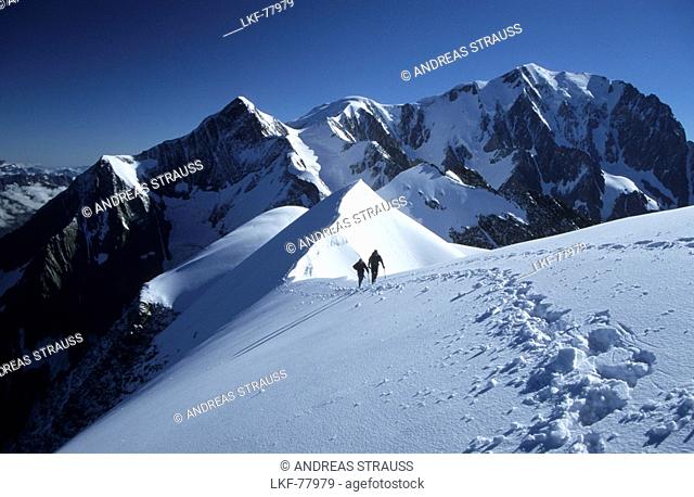 mountaineerers at ridge of Domes de Miage with Mont Blanc in background, Mont Blanc range, France
