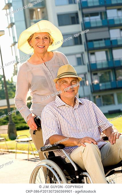 Wealthy senior man in wheelchair with wife retirement