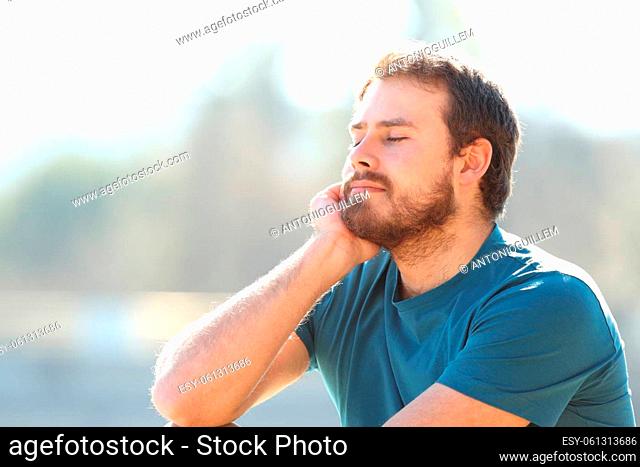 Satissfied man relaxing with closed eyes in nature