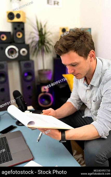 Male entrepreneur checking document while sitting at home