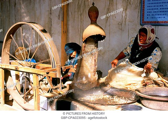 China: Uighur women spinning silk, Atlas Silk Workshop (Atlas Karakhana) in Jiya Village, about 13km northeast of Khotan, Xinjiang Province