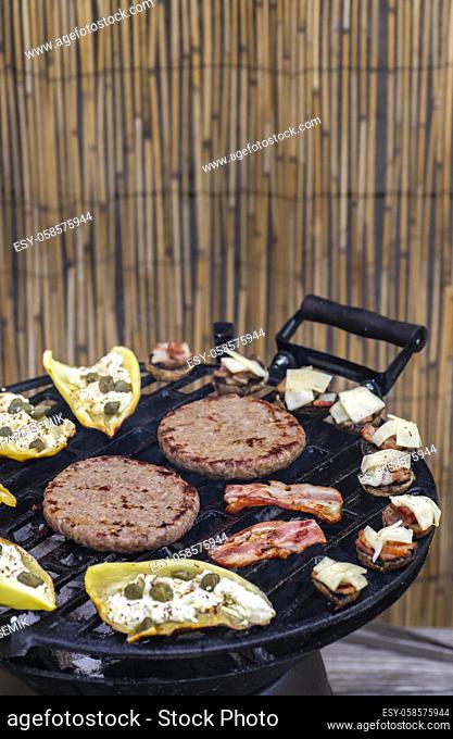 grilled vegetables and meat for burgers on a garden grill