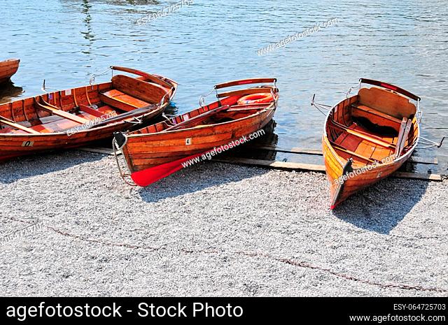 Photographed in Windermere lake, England, several wooden boats on the shore