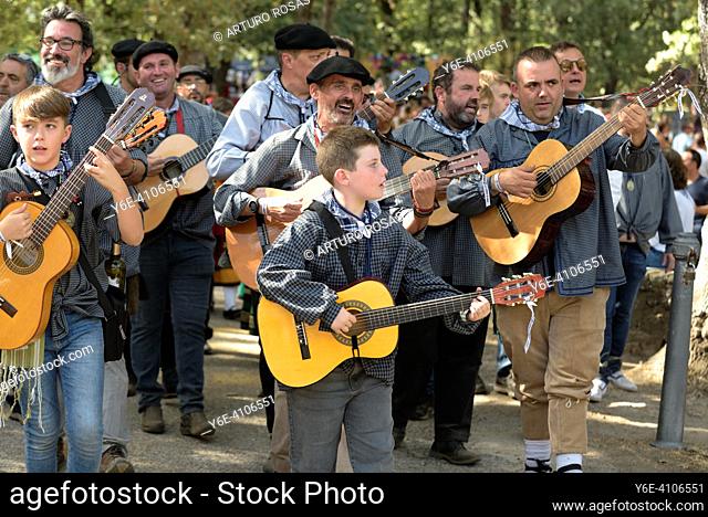 A group with guitars and traditional costumes singing a song during the Virgen de Gracia pilgrimage in San Lorenzo de El Escorial in the Community of Madrid