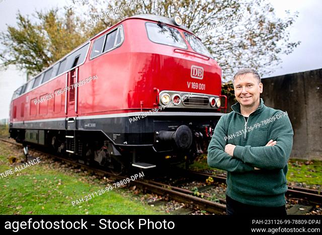 15 November 2023, Lower Saxony, Oldenburg: Roland Sandkuhl, a self-employed train driver from Oldenburg, stands in front of his 1965 DB series V 169 diesel...