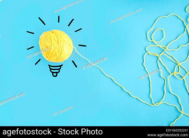 illuminated yarn yellow light bulb blue background