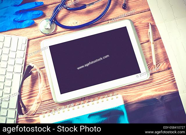 High angle shot of tablet and medical items on wooden table