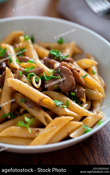 Penne pasta with mushrooms on a plate . High quality photo
