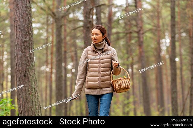 young woman picking mushrooms in autumn forest