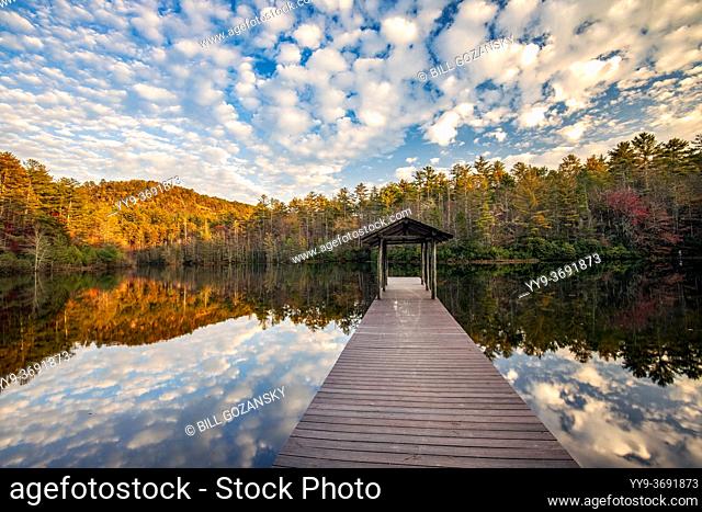 Wooden pier on Lake Dense in autumn with cloud reflections - DuPont State Recreational Forest - near Cedar Mountain, North Carolina, USA