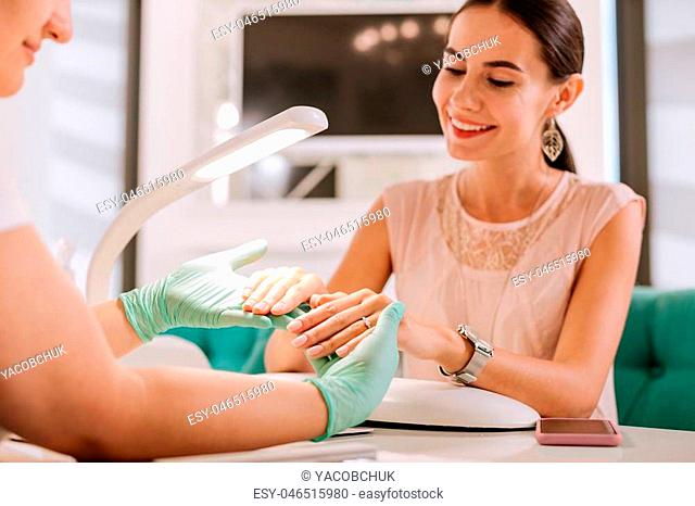 Wrist watch. Charming woman wearing nice wrist watch and nice accessories getting her manicure in salon