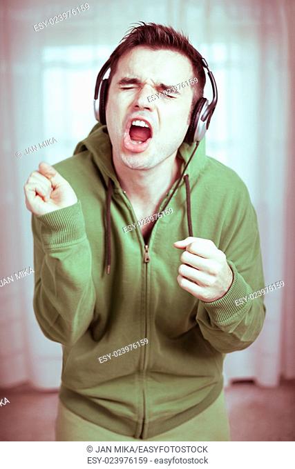 Crazy casual young man with headphones singing