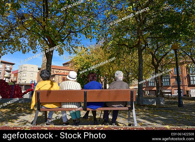 Four older ladies sitting on a park bench in Astorga