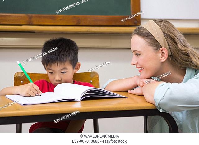 Teacher helping pupil in classroom