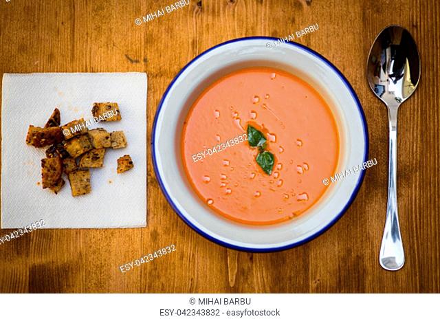 Close up shot of an orange creamy soup with croutons