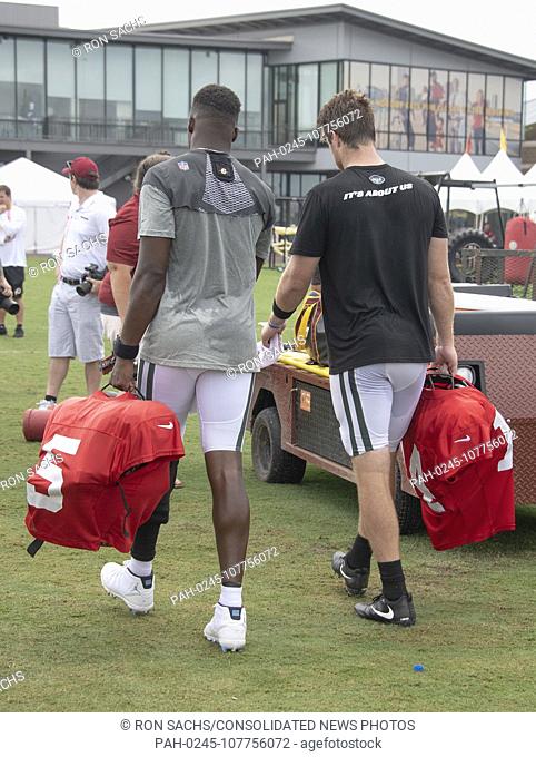 New York Jets quarterback Sam Darnold (14), right, and quarterback Teddy Bridgewater (5), left, carry their gear as they walk off the field after participating...
