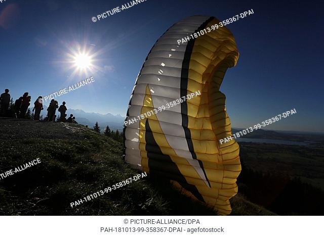13 October 2018, Bavaria, Buching: 13 October 2018, Germany, Buching: A paraglider is pushed to the side by a gust of wind during take-off on the Buchenberg Alm...