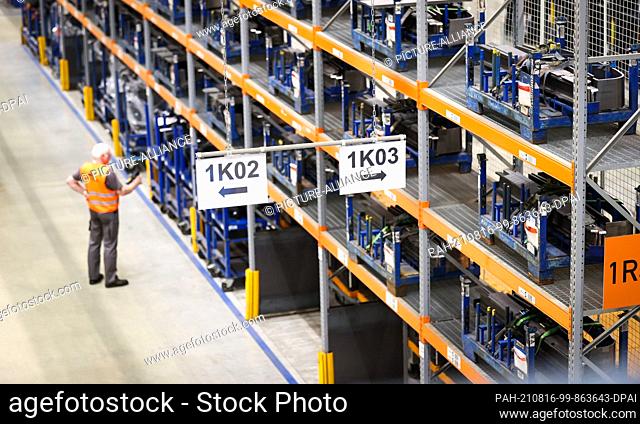 04 August 2021, Hamburg: A logistician works between high racks in a logistics terminal of Still, a manufacturer of forklifts