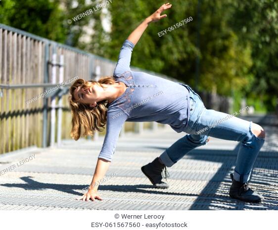Athletic pose of an attractive 22 yo blonde girl on a pedestrian bridge, Belgium