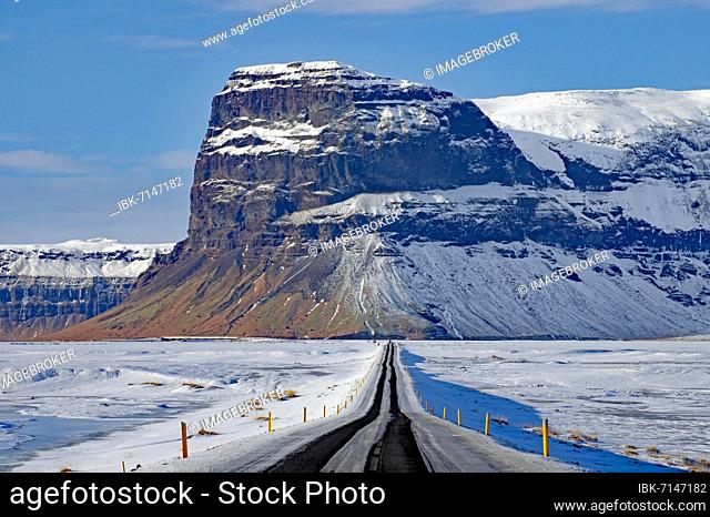 Straight, snow-covered road leading towards a mountain, winter landscape, Lómagnúpur, Skeiðarársandur, South Iceland, Iceland, Europe