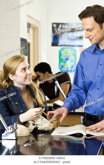 Teacher helping student in science class
