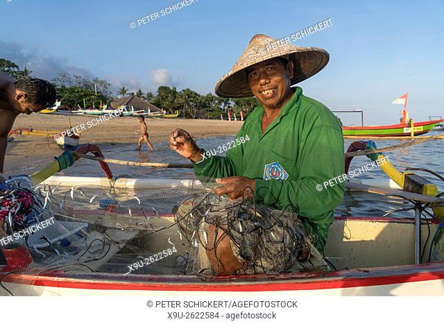 fisherman with boat and net at the beach in Sanur, Bali, Indonesia