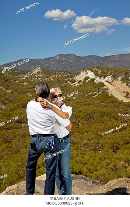 Senior couple hug with desert in background