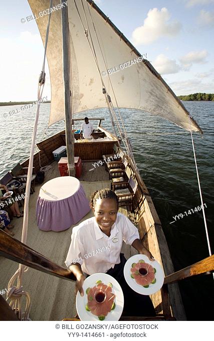 Crew member on Dhow Sailboat with appetizer plates - Hemingways Resort - Watamu, Kenya
