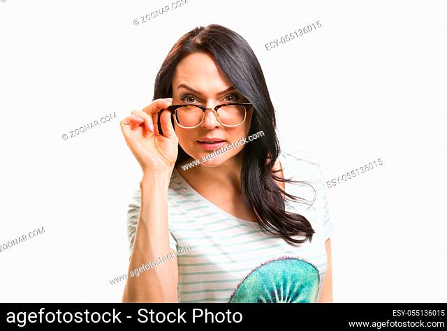 Woman with her glasses lifted up can't see isolated at white background