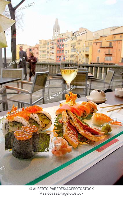 Sushi.'Riba-Sushi Bar'. Houses by Onyar river and Sant Feliu Church in background. Girona, Catalonia , Spain
