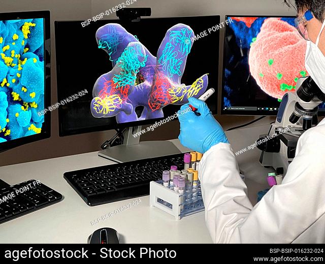 Laboratory technician doing research with images of HIV on a computer