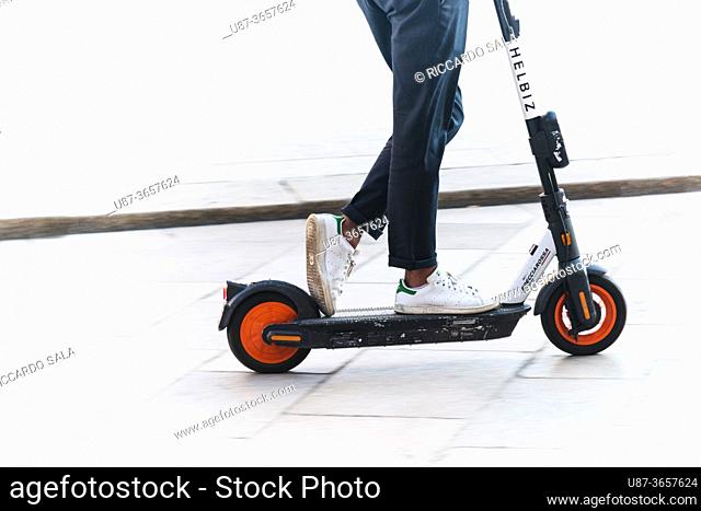 Italy, Lombardy, Milan, Woman Riding Electric Scooter. . .