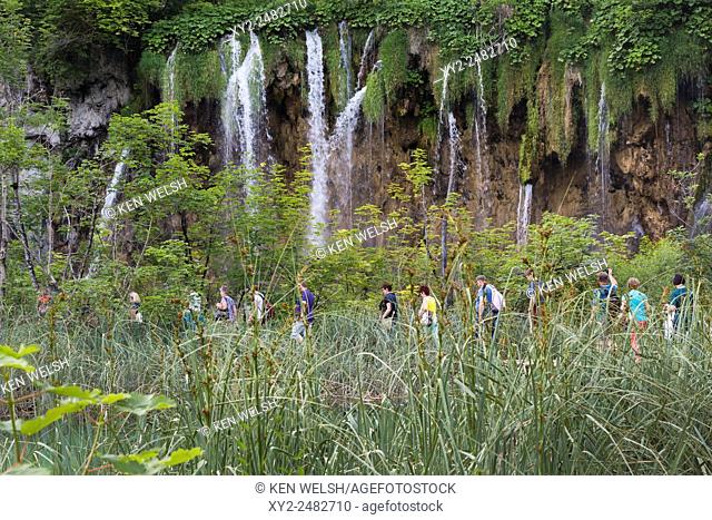 Plitvice Lakes National Park, Lika-Senj County & Karlovac County, Croatia. Visitors walking beside waterfalls within the Park