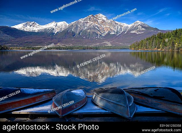 The Patricia Lake with some boat at the lakeshore ready for summer season and there is the beautiful reflecting Pyramid Mountain in the background