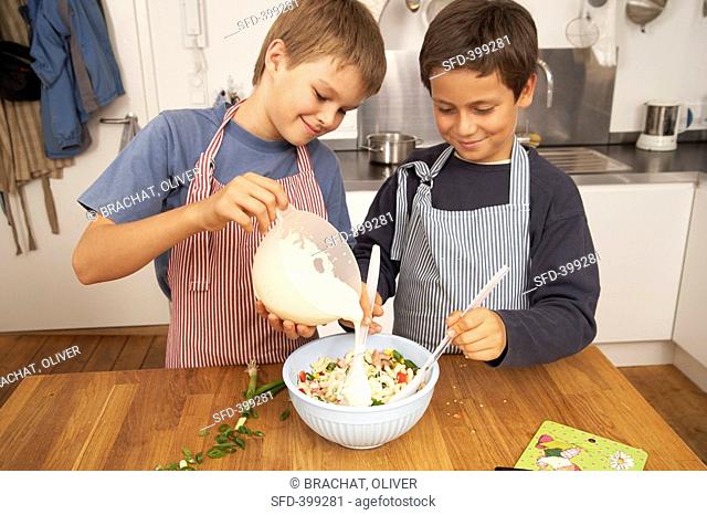 Two boys making pasta salad