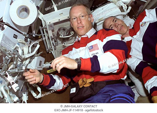 Onboard the Space Shuttle Discovery, astronauts Patrick G. Forrester (left) and Daniel T. Barry check out some of the equipment they will be working with on...
