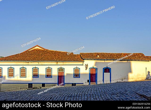 Facade of old house in colonial style architecture in the city of Ouro Preto, Minas Gerais with blue windows and door and the sky in backgroud