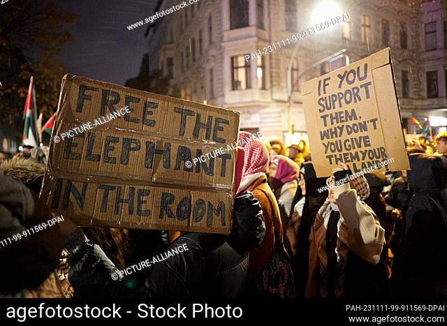 11 November 2023, Berlin: Participants in a demonstration hold placards reading ""Free the elephant in the room"" and ""if you support them